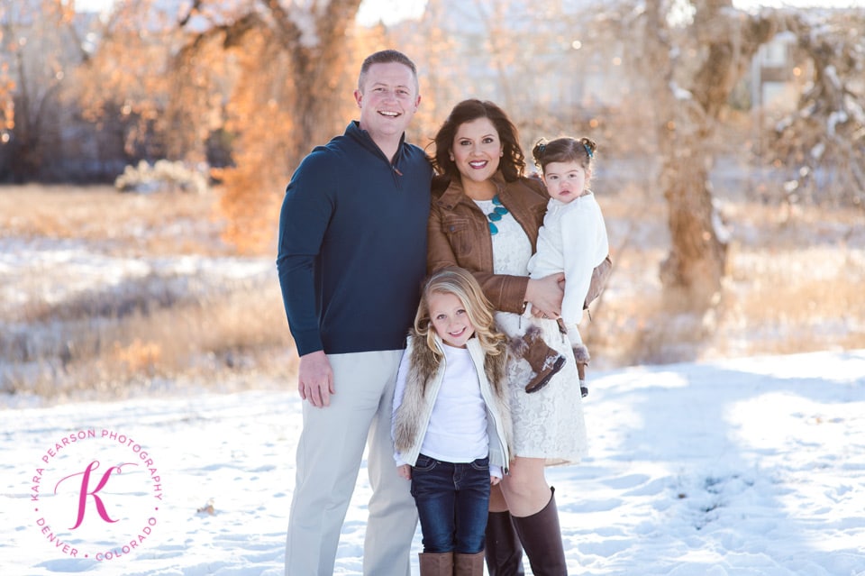 A family smiles while in the snow in December