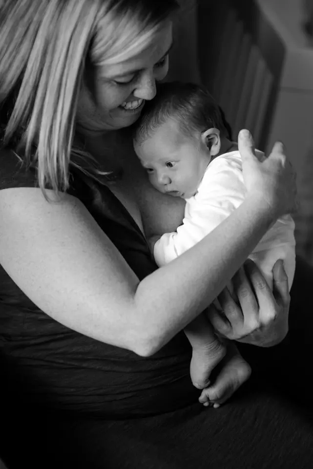 mom cuddles newborn