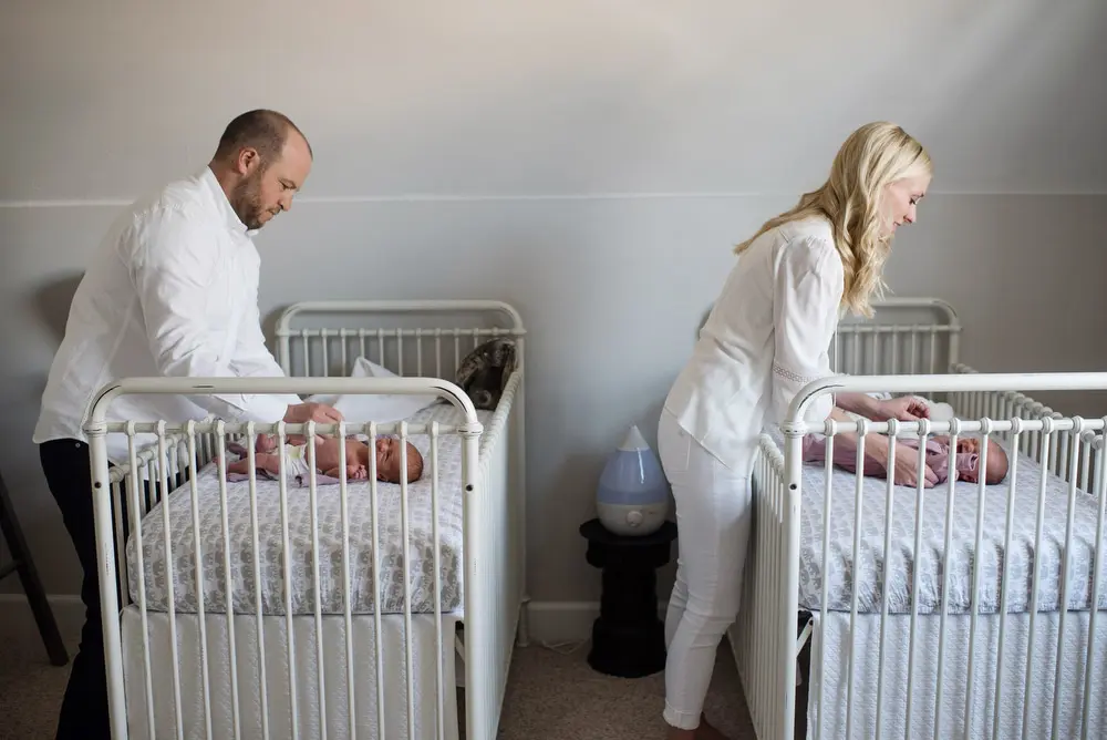 parents with twin cribs