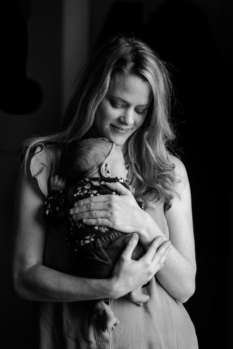 portrait of mom holding newborn girl