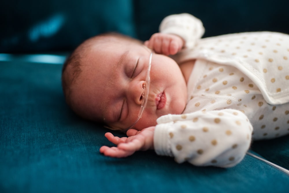 a baby girl sleeps during her preemie newborn photography