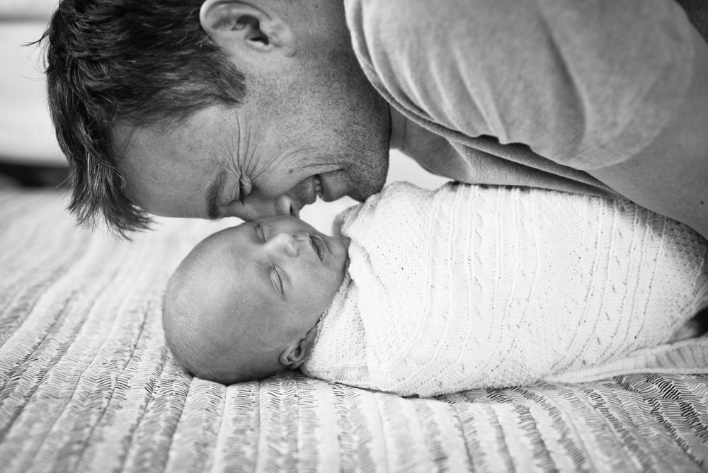 dad snuggles with newborn son