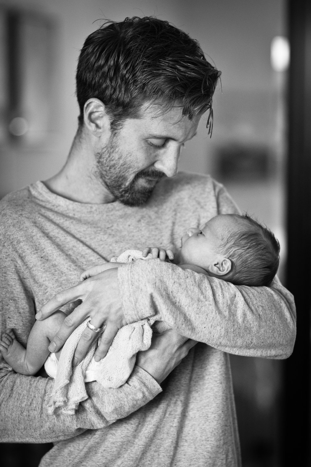 dad cuddles his newborn baby boy