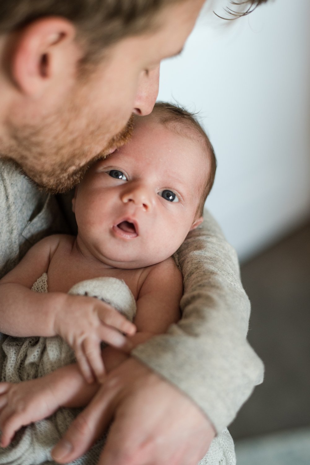 dad kisses his newborn baby in Denver