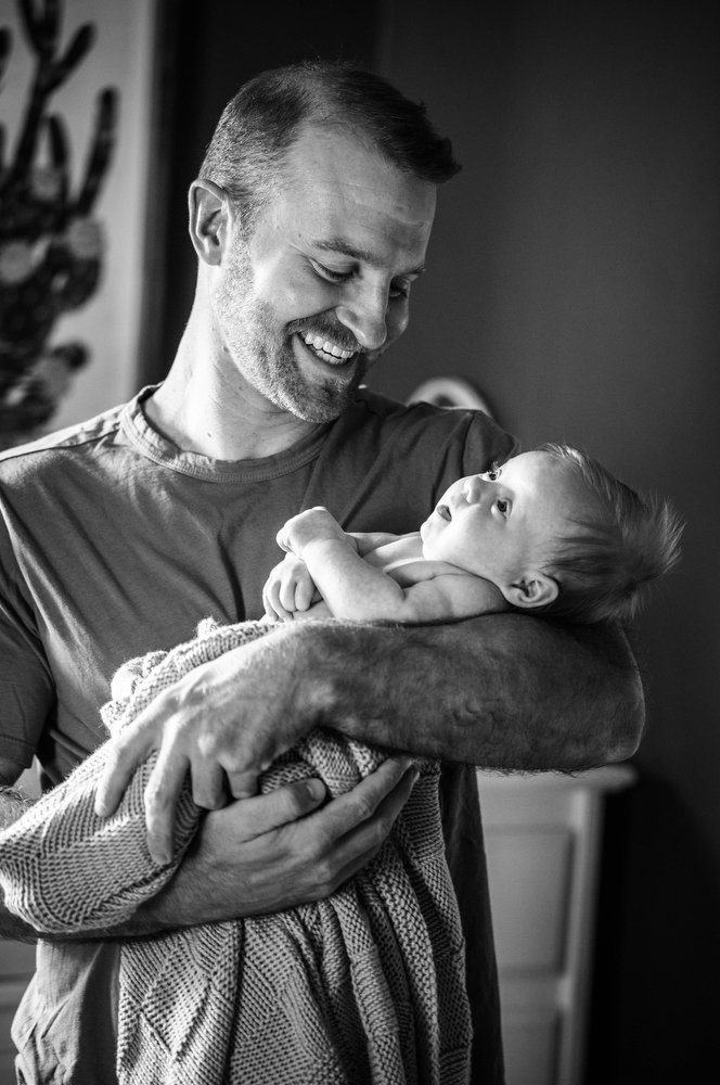 dad holding newborn baby girl for portraits in Denver