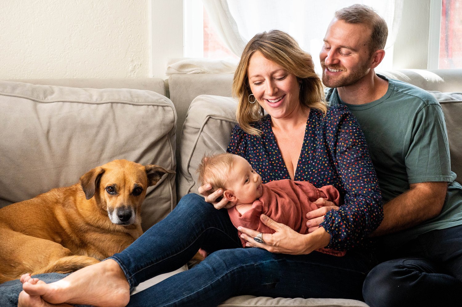 parents sit with their dog and baby in Denver