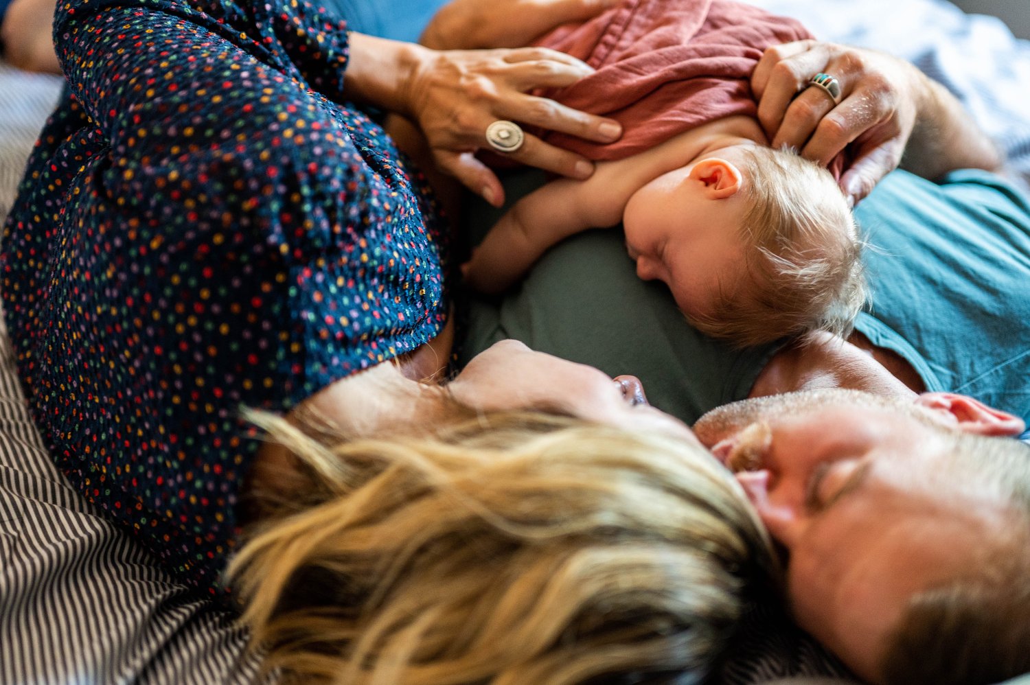 parents snuggle their Denver newborn baby