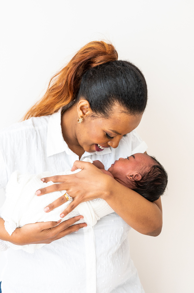 mom smiles at newborn girl