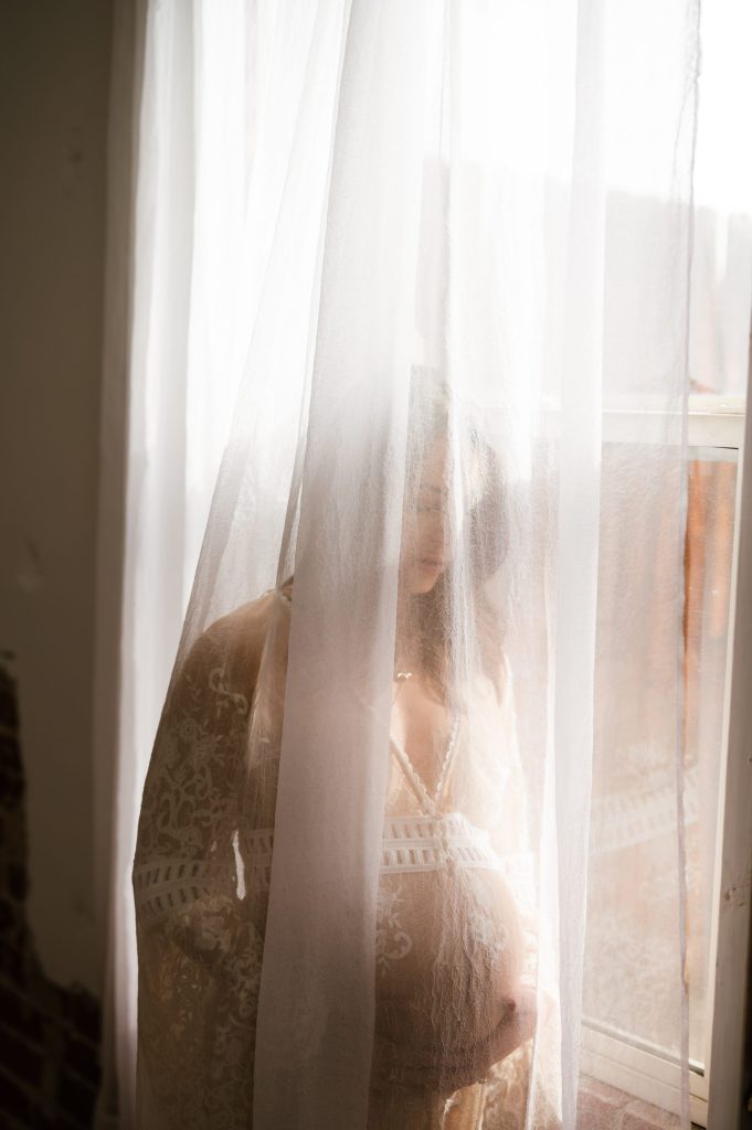 pregnant woman through a curtain