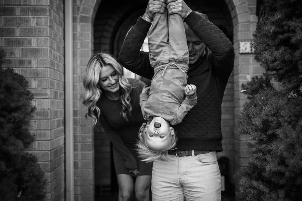parents hold kid upside down