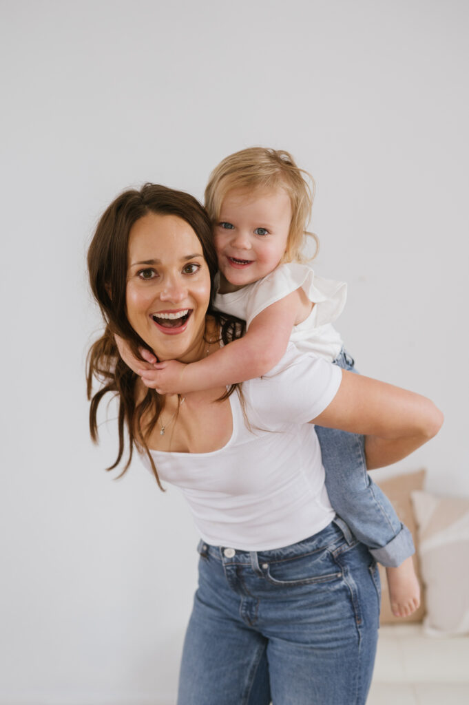 Daughter rides piggy back on mom