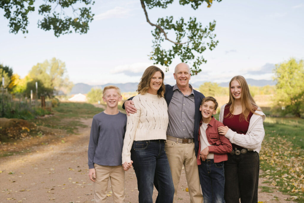 A family poses for photos with mountains in the background in Littleton.