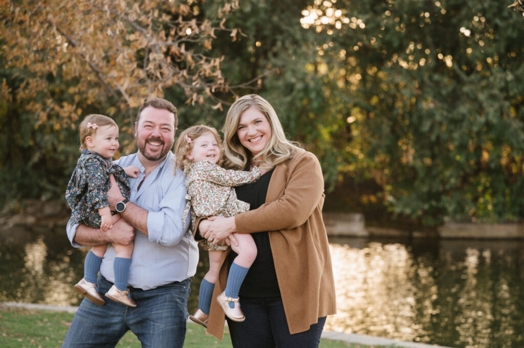 Parents smile with a lake in the background in Wash Park