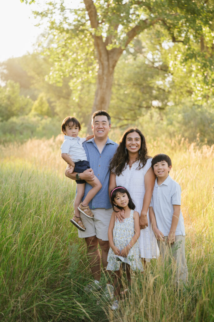 A Denver family poses for a photo in a park.