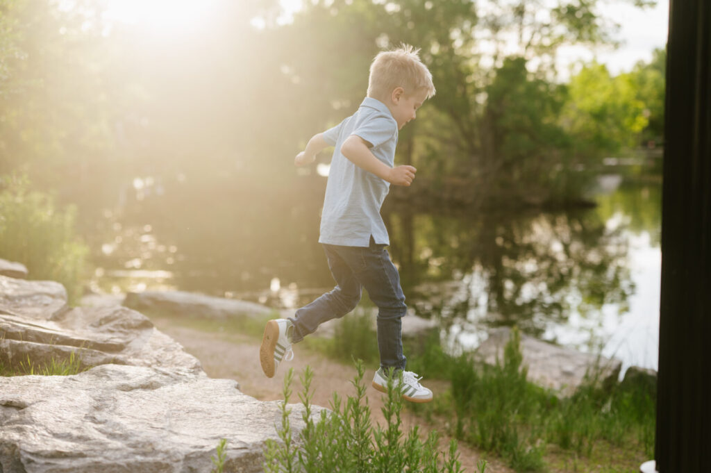 A boy jumps on rocks in Littleton.