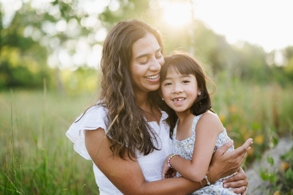 Golden light shines on a mom and her daughter during a summer portrait session in Denver.