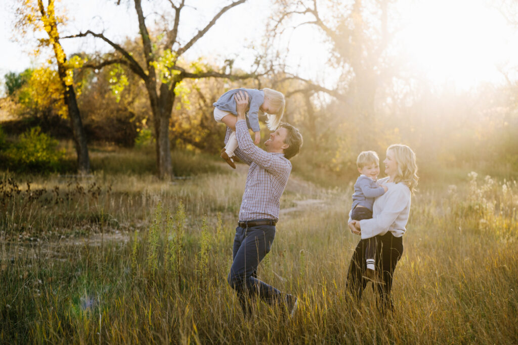 A family tromps around a field in the fall in Denver.